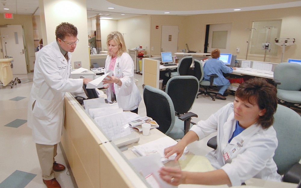 W. Edward Richards, MD, consulting with nursing staff at the UC Barrett Cancer Institute at University Hospital about a patient. 