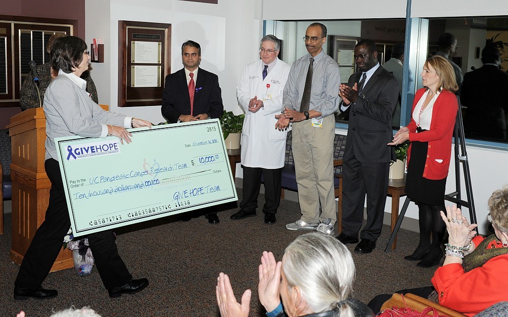 Susan Pavlech of Give Hope presents the UC pancreatic cancer team with a check for $10,000. 