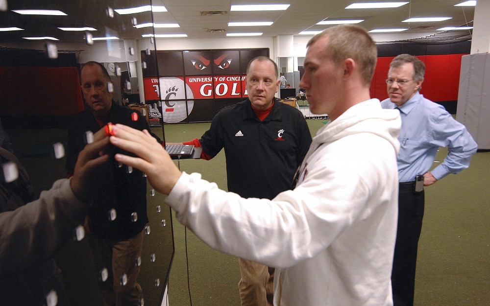 Joe Clark, PhD (left), oversees enhanced vision training for UC baseball team member David McInerney, a freshman catcher. At right is Kevin Corcoran, OD, of the Cincinnati Eye Institute.
