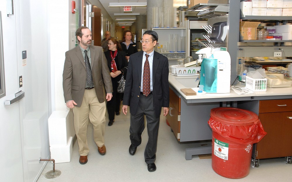 Kim Seroogy, PhD (left), leads Dennis Choi, MD, PhD, on a tour of the Selma Schottenstein Harris Lab for Research in Parkinson's in the CARE/Crawley Building. 