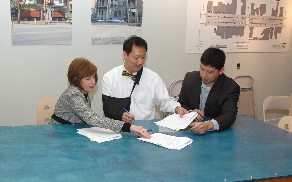 UC Provost Santa Ono, PhD, (center) with  Dorothy Air, PhD, associate vice president for entrepreneurial affairs and technology commercialization, and Terry Chan of the Midwest EB5 Regional Center, at the signing of the formation of the UC Technology Commercializaiton Accelerator.