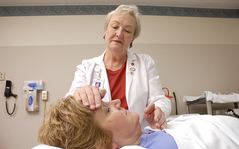 Judy Bowers, a nurse at University Hospital, practices Healing Touch, an energy, complementary medicine therapy, on nurse Elizabeth Wabnitz. 