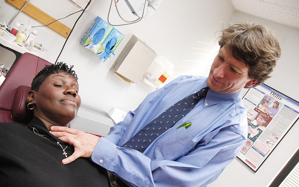 David Steward, MD, demonstrates how to check for nodules on the thyroid gland.