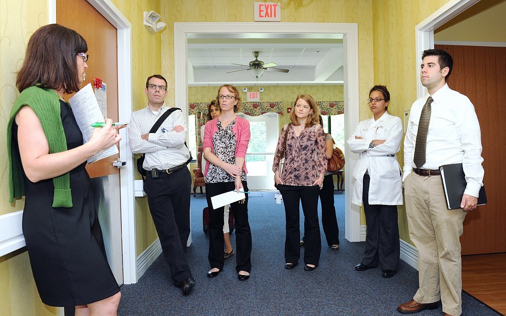 Residents in the Geriatric Resident Interdisciplinary Experience (GeRIE) tour the Alois Alzheimer's Center to observe the agency which serves this older adult population. Among the learners are those from the colleges of medicine, pharmacy and nursing, making the experience interprofessional.