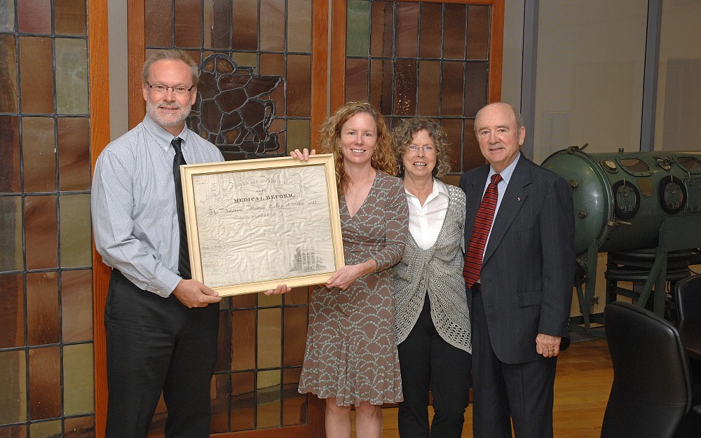 Stephen Marine, assistant dean of special collections at the UC Libraries, receives a rare 1843 Botanico Medical College of Ohio diploma from Allison Higgins, MD, of Denver, and her parents, Becky and Jerry Higgins of Clayton, N.C. The diploma was awarded to their ancestor, Henry Randolph Higgins.