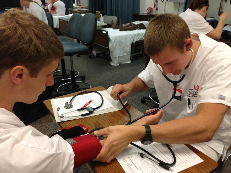 A male nurse takes a blood pressure reading.