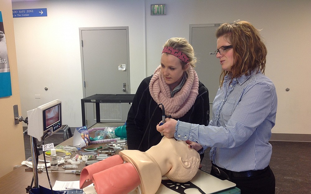 Nurse anesthesia student Meghan McDonald demonstrates the intubation process to senior BSN student Erin Williamson. 