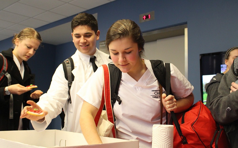 Nursing students attended the UC College of Nursing's Apple Distinguished Program celebration this week. Here, they're grabbing cookies appropriately decorated with an apple.