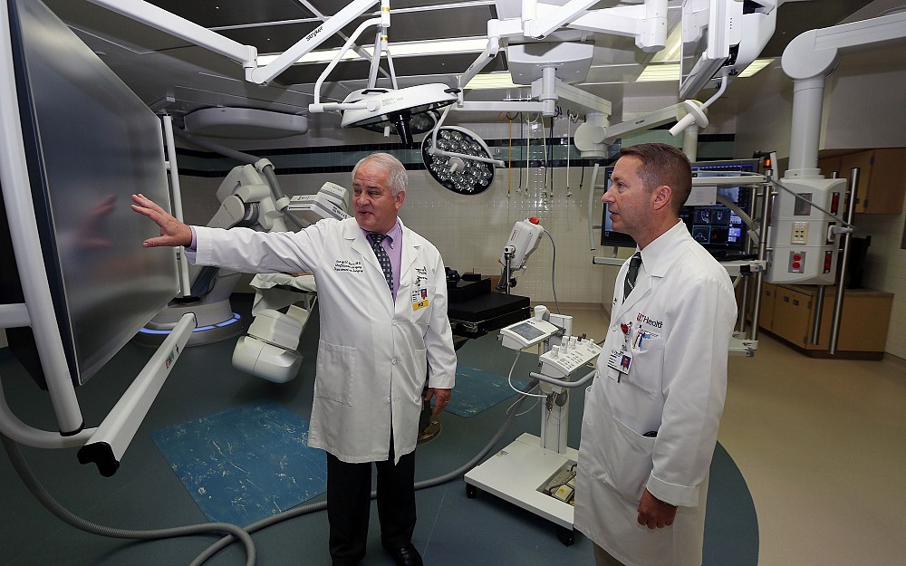 George Meier, III, MD, director of the Division of Vascular Surgery, speaks with Joseph Konys, physician assistant in cardiac surgery, during an open house for UC Medical Center's hybrid operating room.