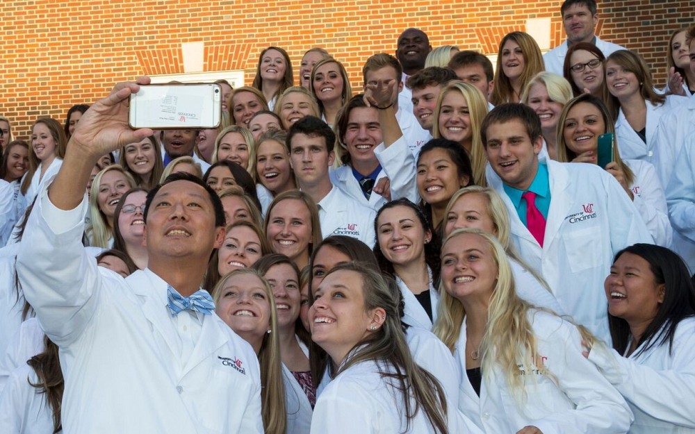 President Santa Ono, PhD, takes a "selfie" with nursing white coat recipients. 