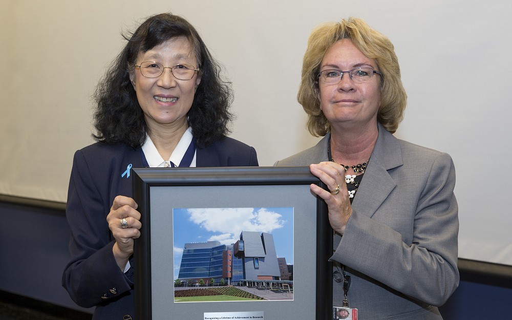 Shuk-Mei Ho, PhD (left), receives her Lifetime of Achievement in Research Award from Melanie Cushion, PhD, senior associate dean for research.
