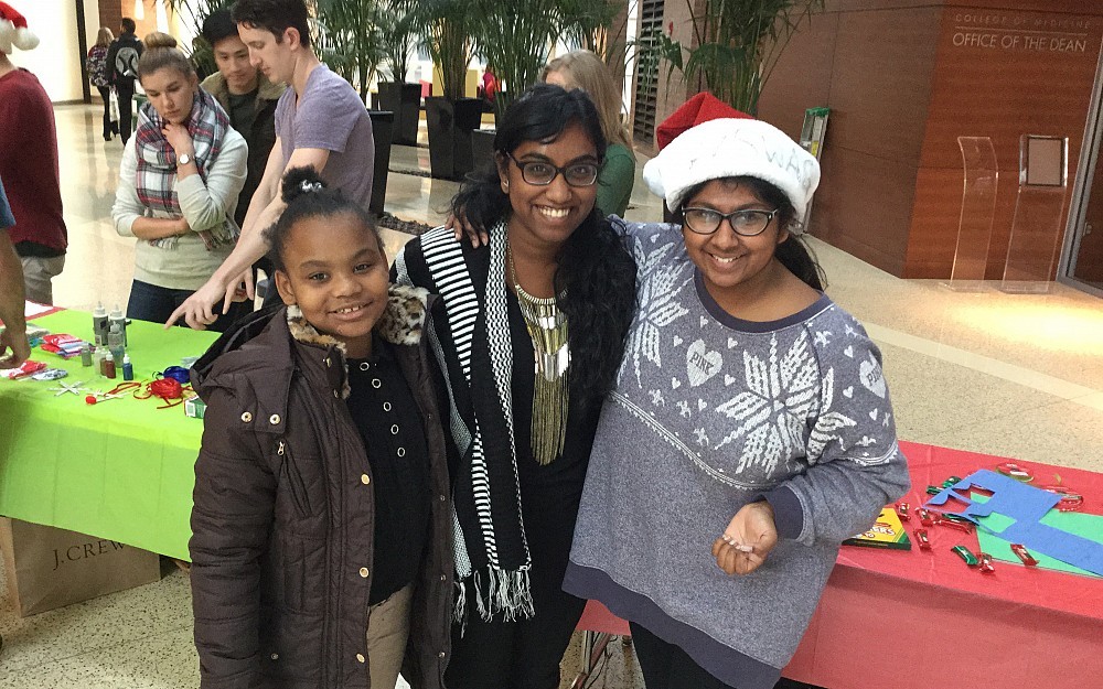 
Rayonna Kelley Jones, a South Avondale Elementary student, joins her mentor med student Mahima Venkatesh and Thara Nagarajan at the COM Holiday Festival in CARE/Crawley.