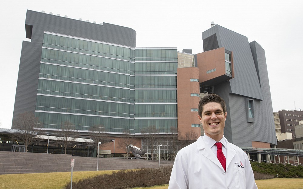 Craig Hansen, a fourth-year medical student, is featured in front of the CARE/Crawley Building.