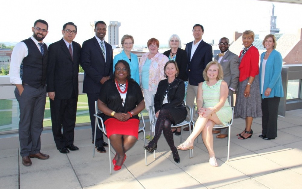 Members of the UU HEALTH Community Advisory Board gather at a celebration in May 2016. Pictured in the back from left are George Adly, Ron Reblando, Sean Rugless, Colleen OÂ Toole, Sharron DiMario, Francie Wolgin, President Santa Ono, Jamahal Boyd, Judith Warren and CAHS Dean Tina Whalen. Seated in the front from left are College of Nursing Associate Dean Karen Bankston, Dean Greer Glazer and Tammy Mentzel. 
