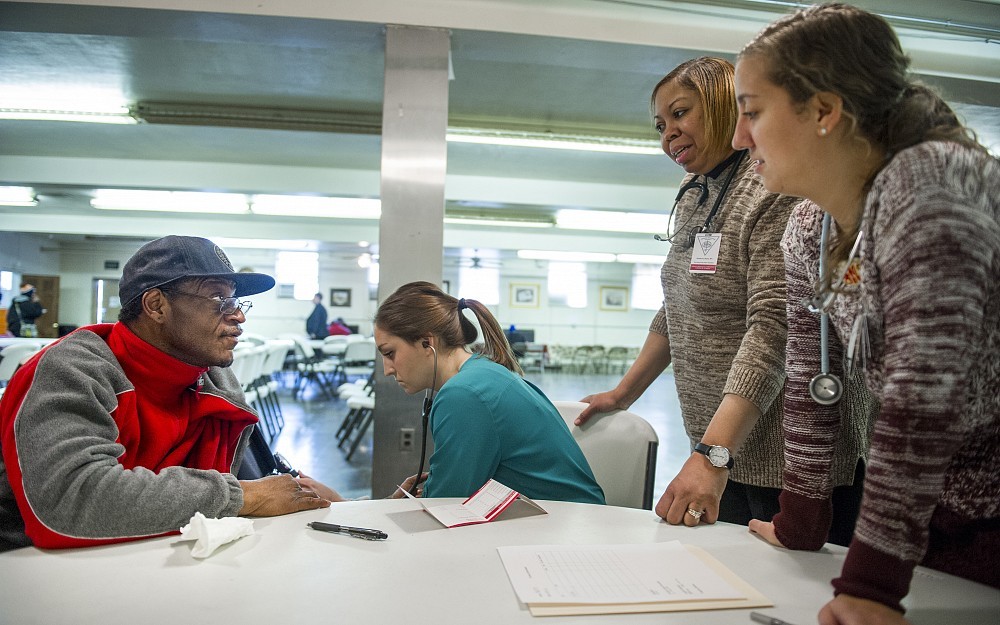 UC College of Nursing student Natalie Kaniss, second from the left and Jennifer Murphy, right, along with Kim Duett, MSN, RN, UCMMC work with a client at a Food for the Soul session at St. John's AME Zion Church in Cincinnati