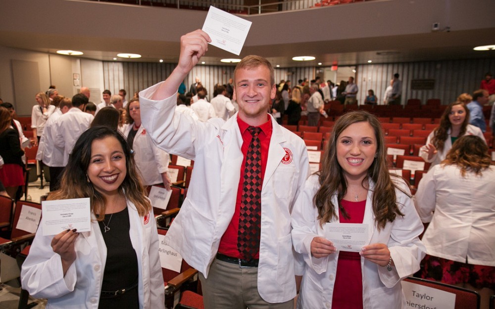 Pharmacy Class of 2020 Students Hold Cards With Names of White Coat Donors 