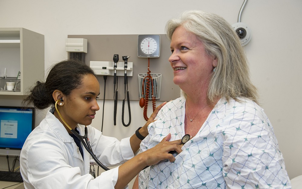 Maya Antonine, a fourth-year med student, exams Paula Hoekzema, a standardized patient.