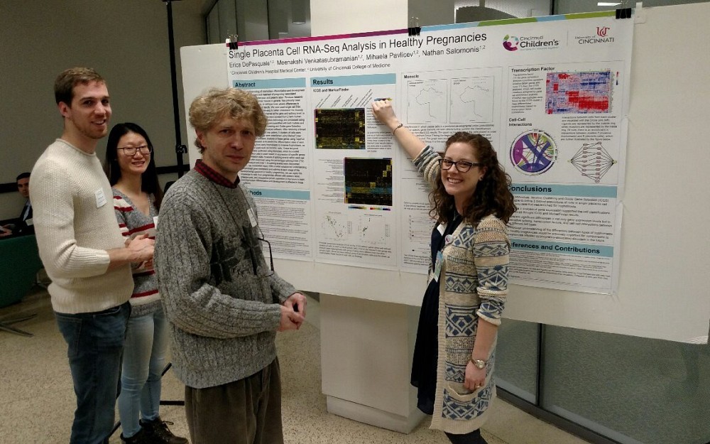 Erica DePasquale, right, presents her research at the College of Medicine's graduate fair. Jarek Meller, PhD, center, is also shown.