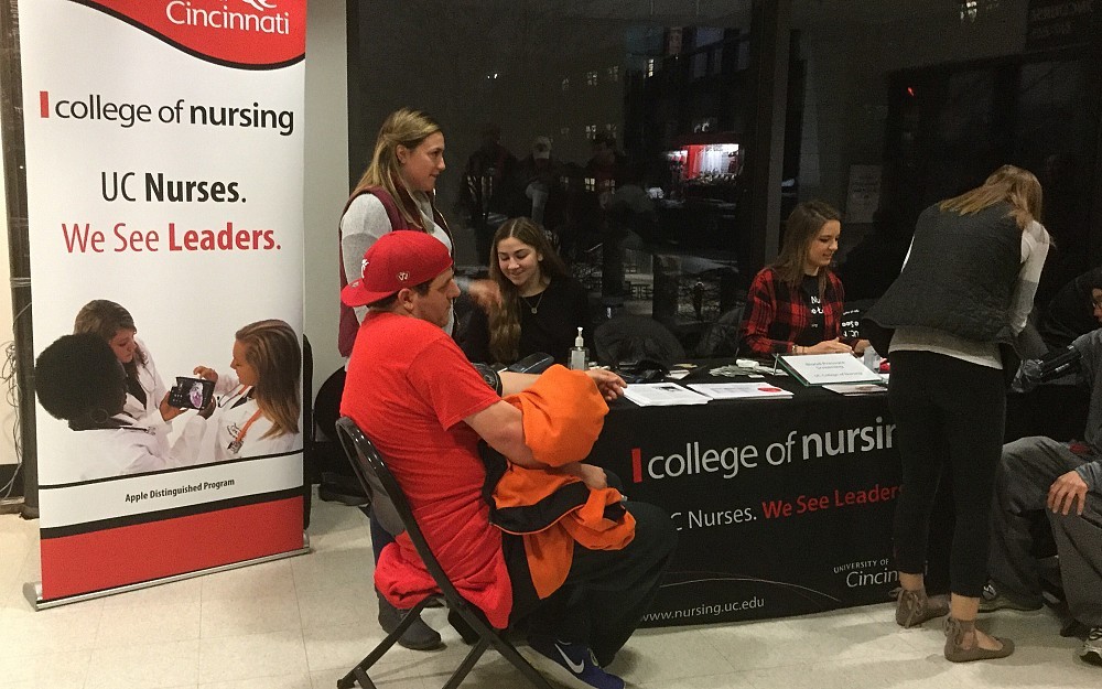Nursing students Danielle D'Anna, Danielle Ahlers, Mallory Telles and Hannah Gunn (back to camera) provide blood pressure screenings at the men's basketball game on Feb. 8, 2017