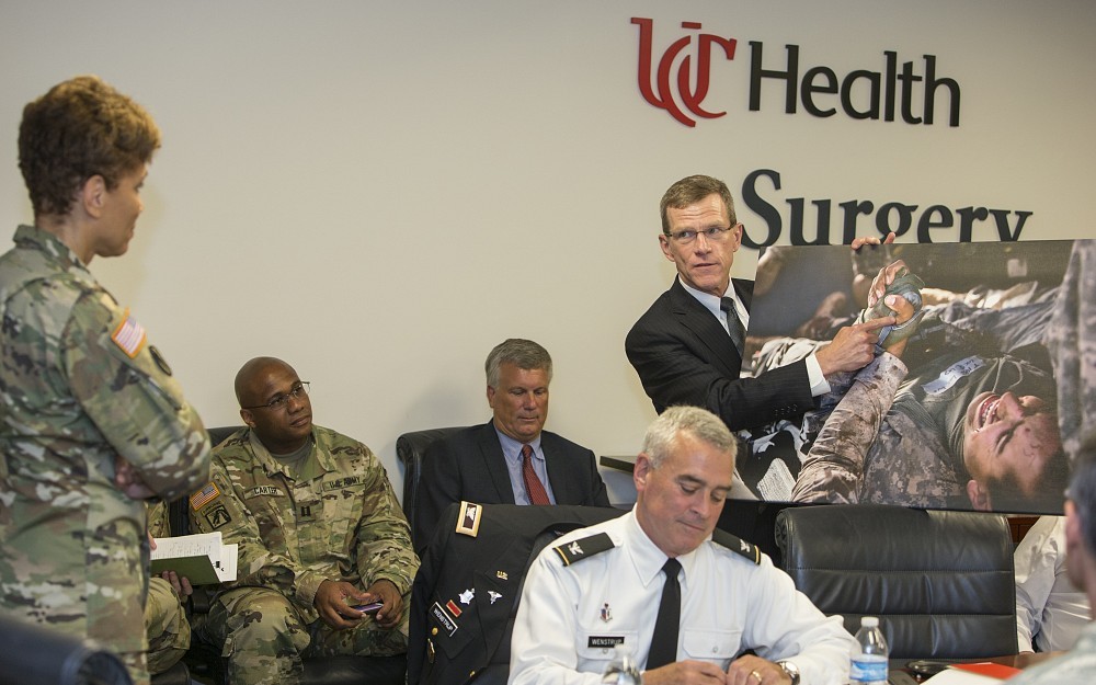 Lt. Gen. Nadja West, US Army Surgeon General, left, is presented with a photograph showing field care of a wounded soldier from Jay Johannigman, MD