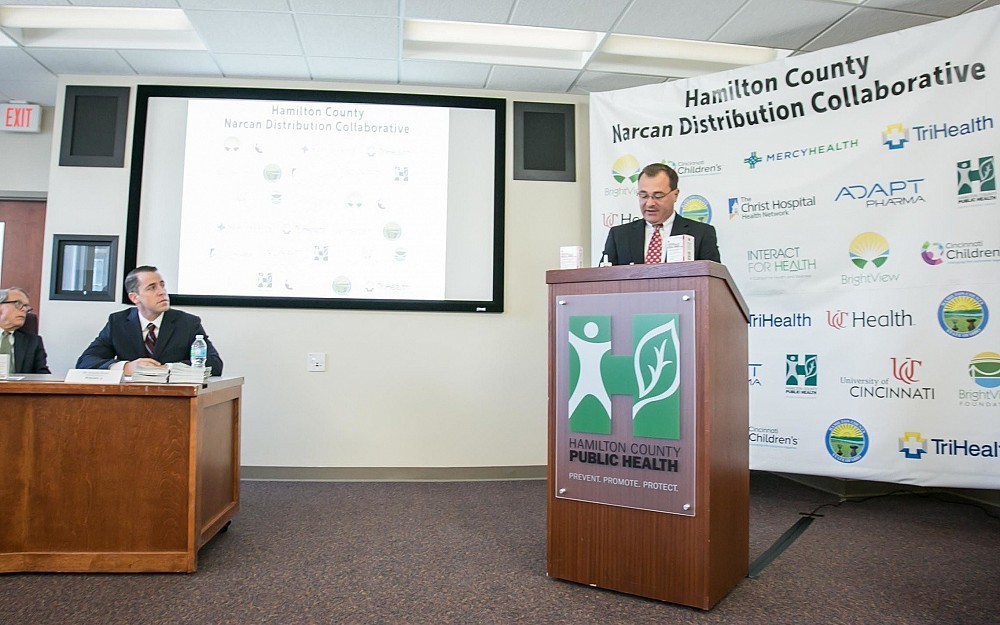Michael Lyons, MD, associate professor in the Department of Emergency Medicine speaking at the Hamilton County Narcan Distribution Collaborative news conference with Ohio Attorney General Mike Dewine and Shawn Ryan of BrightView Health looking on, Sept. 7, 2017
