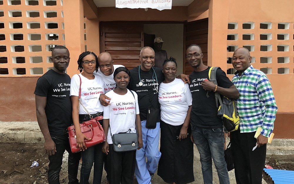 Cheedy Jaja, PhD, center in blue scrubs pants, at the sickle cell clinic he founded in Sierra Leone.