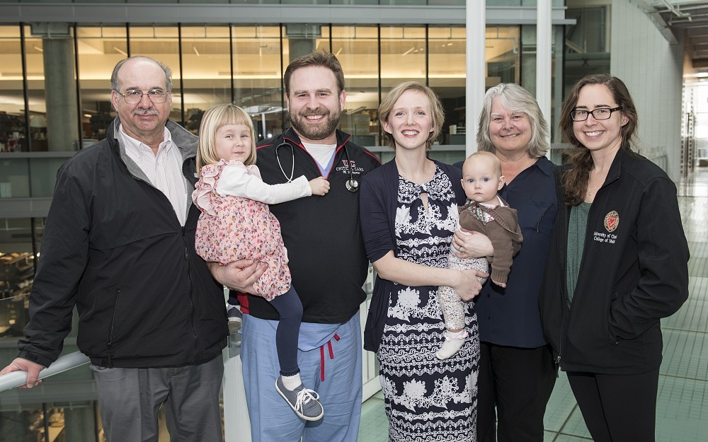Michael Hellmann, MD, (stethoscope) holds daughter Josephine, and is joined by his wife Jennifer Hellmann, MD, shown holding daughter, Isabelle and his mother Gail Hellmann, MD, and sister Elizabeth Hellmann. Far left is Robert Hellmann, MD.