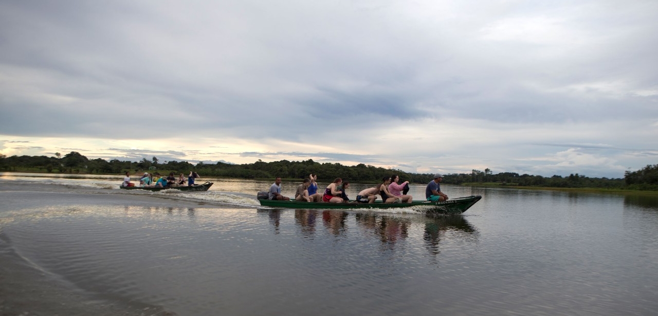 A group of UC Honors students on two boats tour the Amazon River on a study-abroad trip.