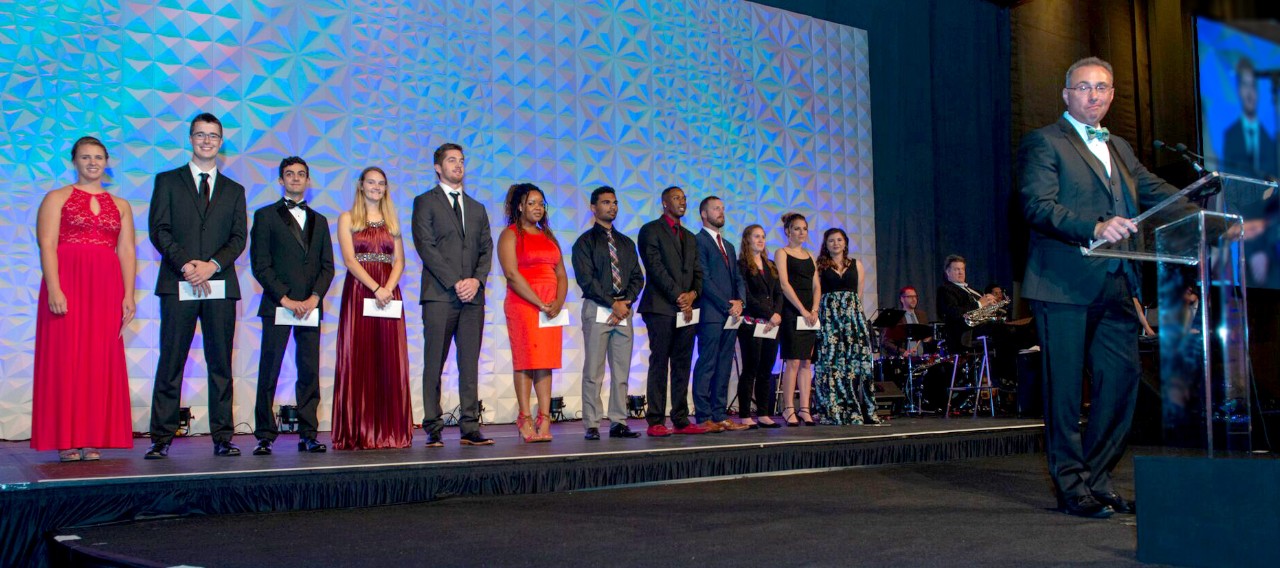 Students on stage receiving scholarships at gala