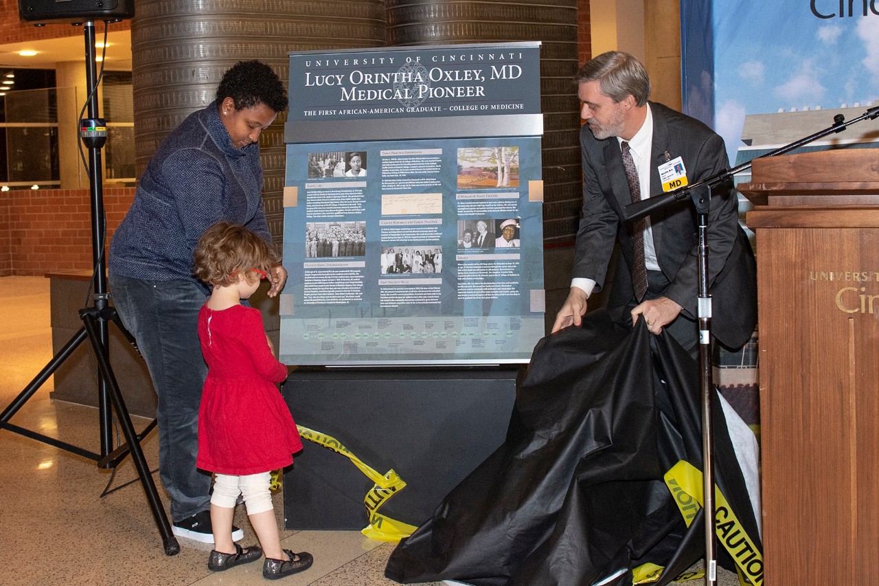 The family of Lucy Oxley, MD, unveils commemorative panel.