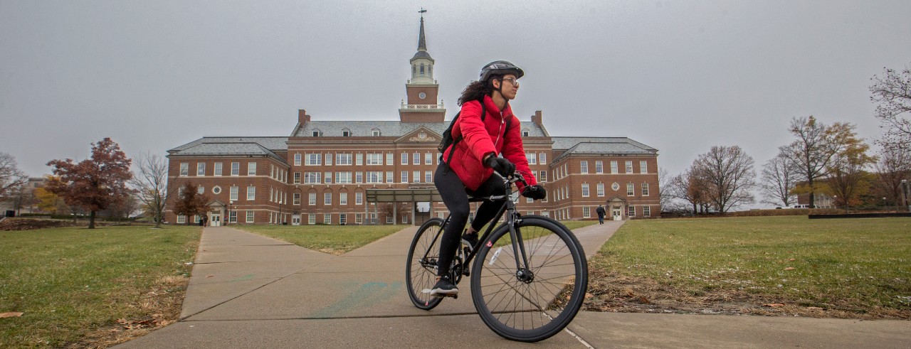 UC student Sakina Jarmon rides her bike in McMicken Commons
