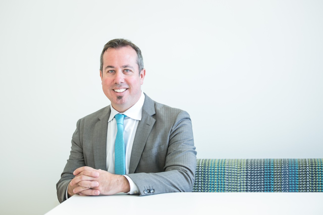 Dean Neil MacKinnon, PhD, sitting in a chair
