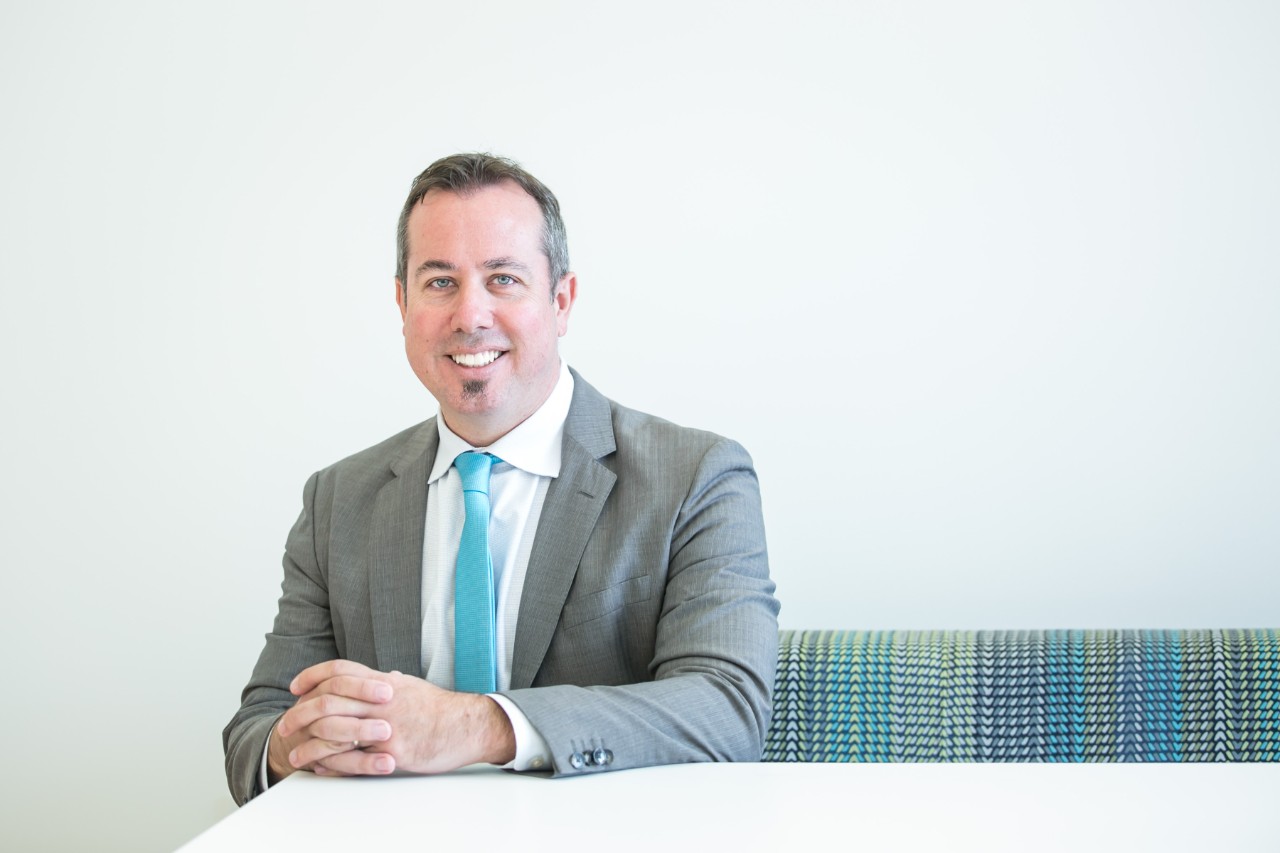 Dean Neil MacKinnon, PhD, sitting in a chair 