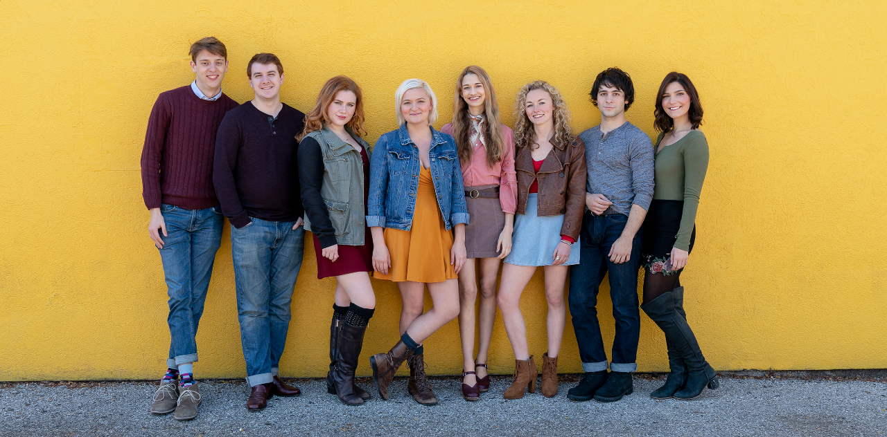 Graduating seniors or CCM Acting's Class of 2019 lined up against a yellow wall