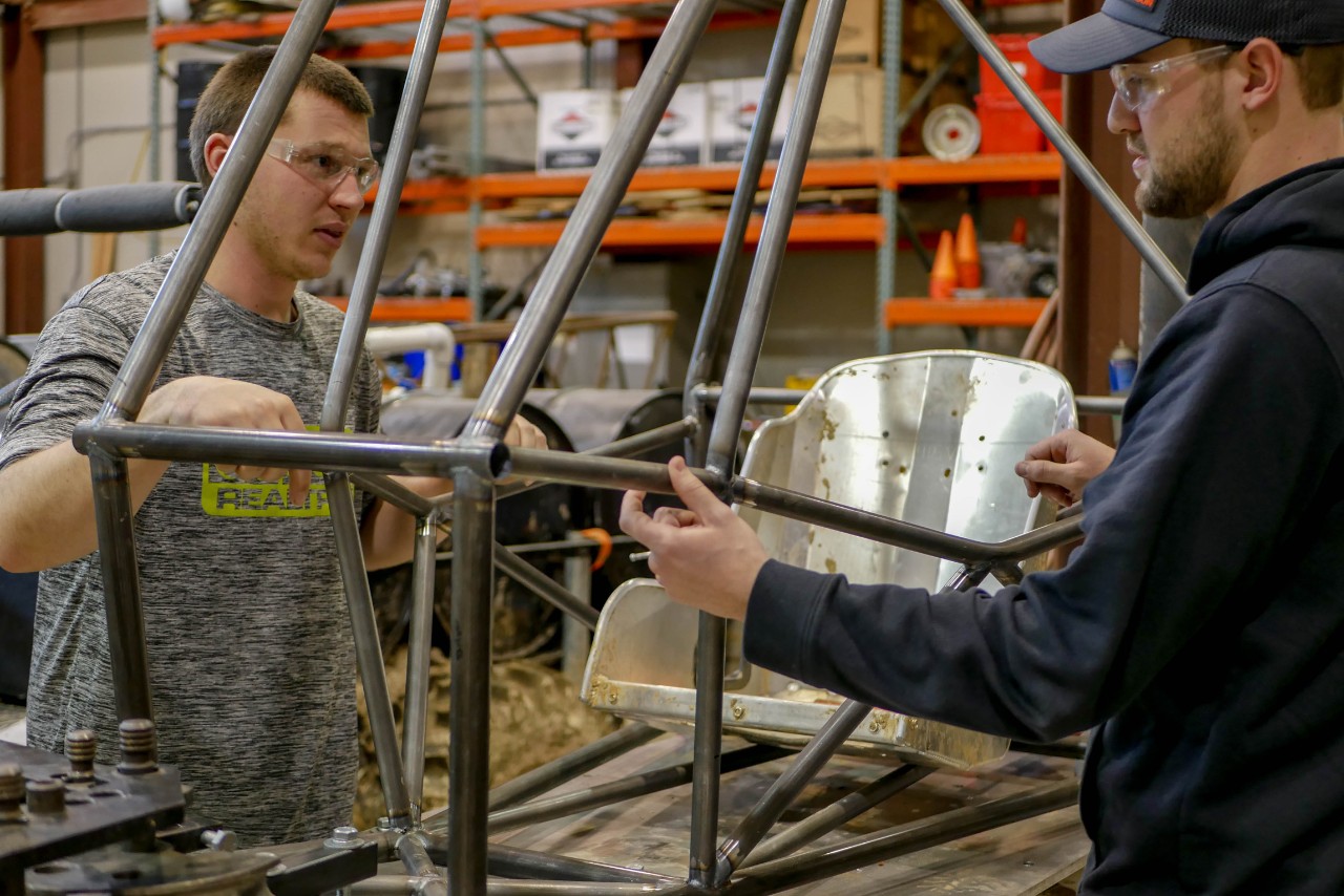 students work on frame of new car