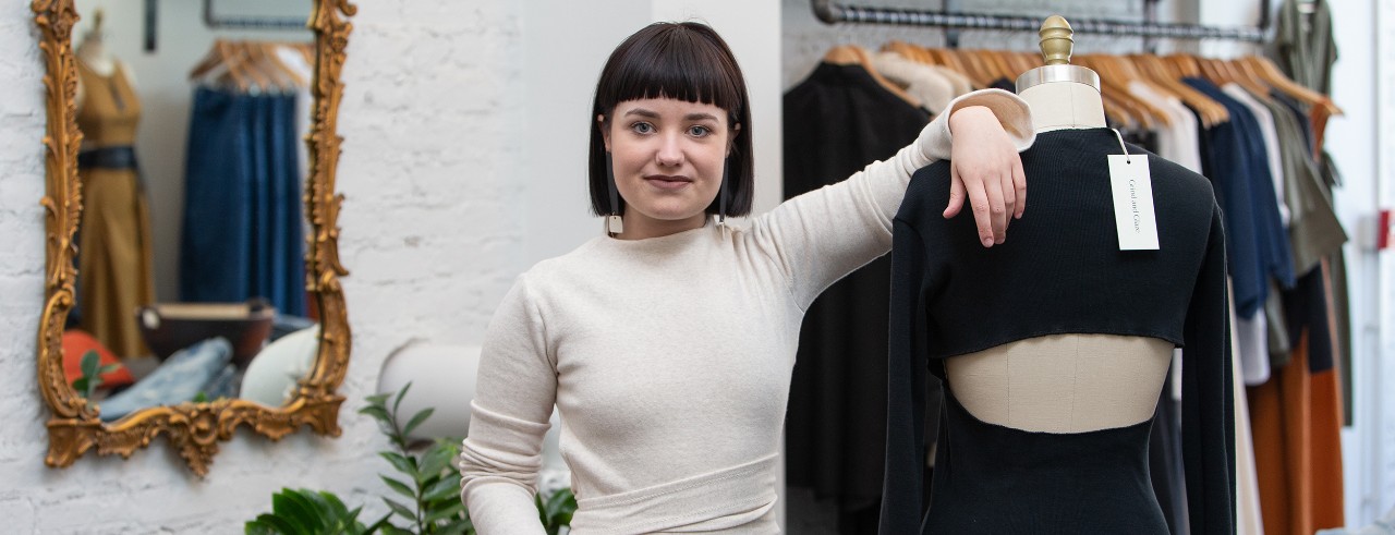 Tessa Clark poses with her designs on a dress form in her boutique