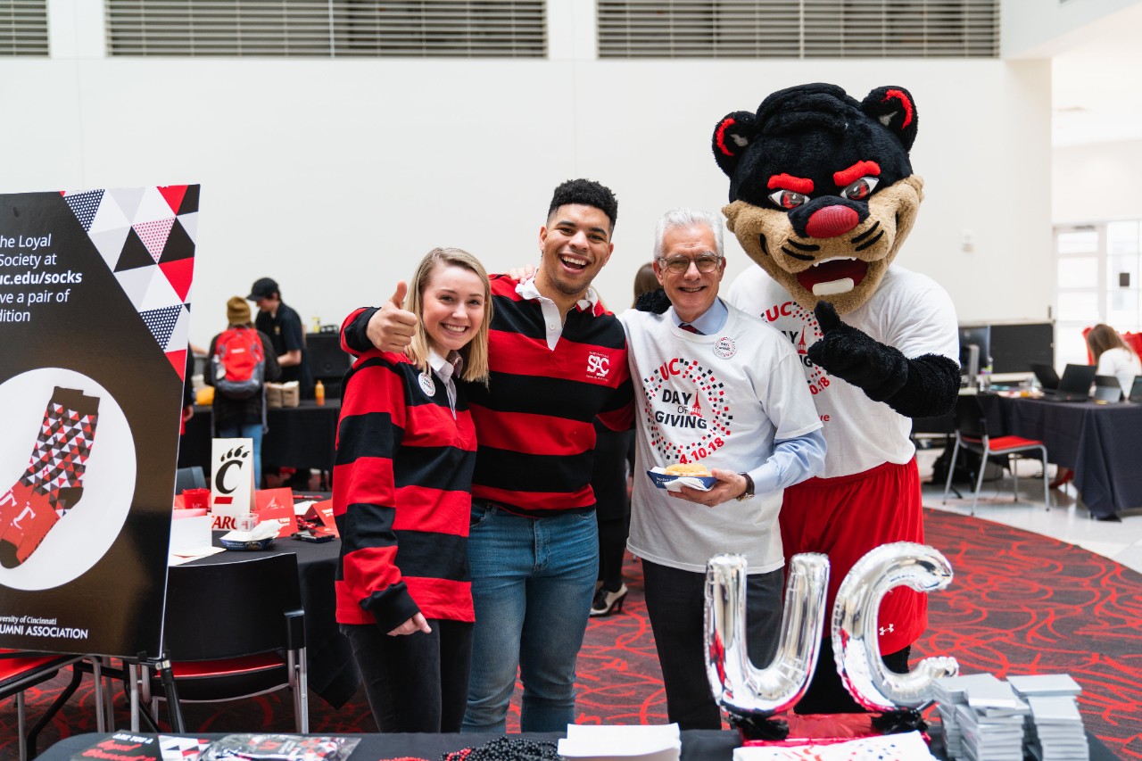 Two students pose with UC Foundation President Peter Landgren