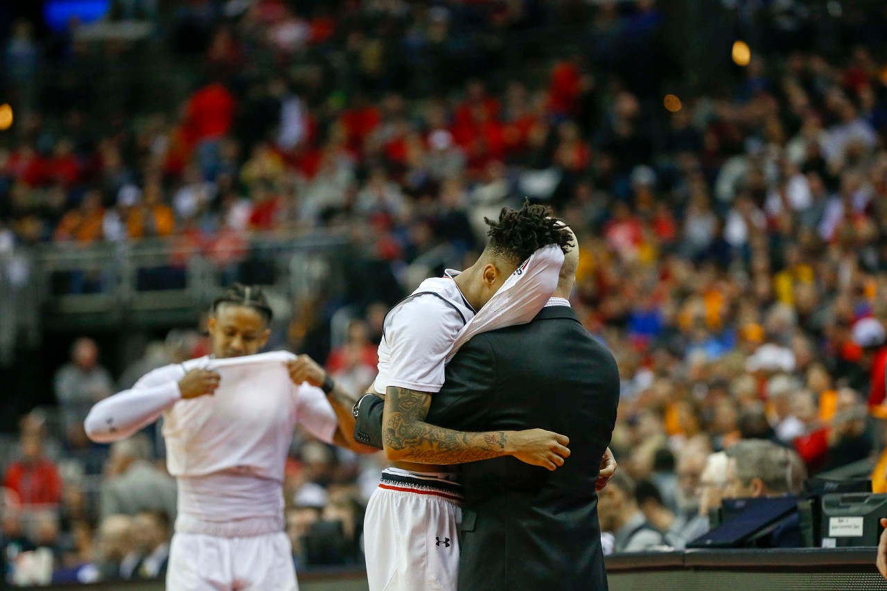 Mick Cronin hugs Cane Broome as Broome and Justin Jenifer exit the court in the final seconds of the Bearcats' 79-72 loss to Iowa on Saturday, March 22