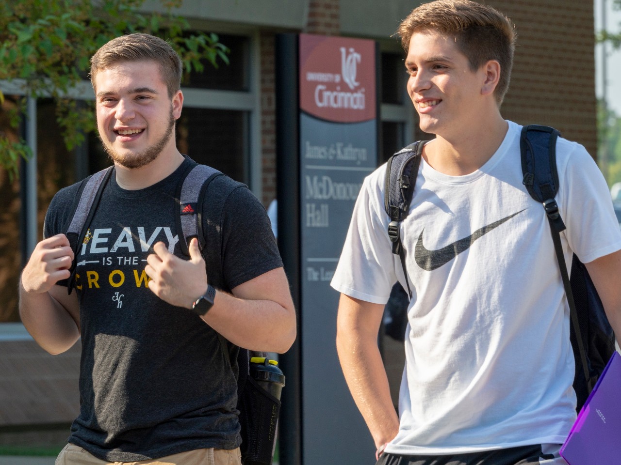 Male students walking across UC Clermont's campus