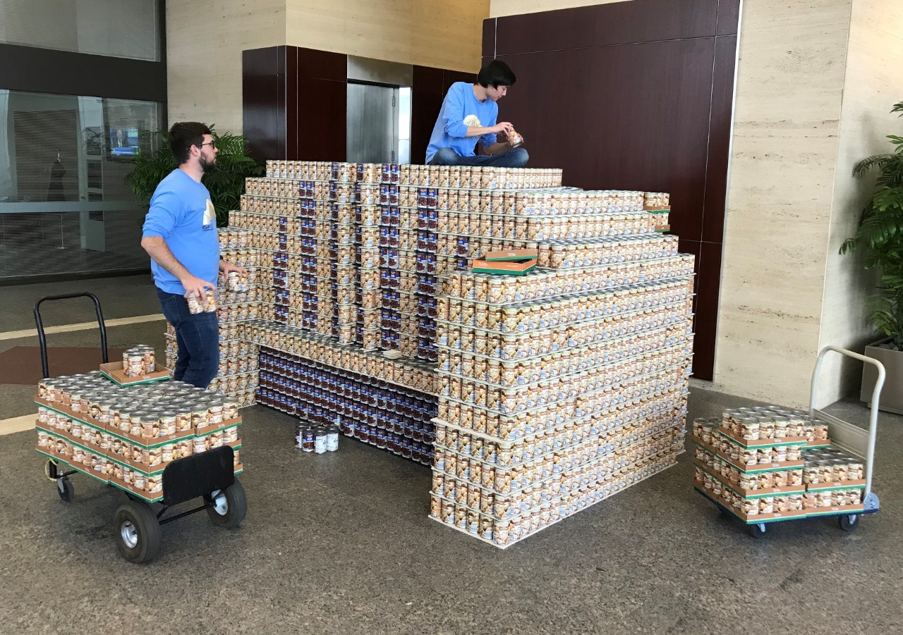 students build canned food structure at event