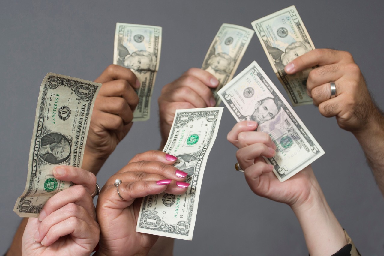 Hands holding dollar bills