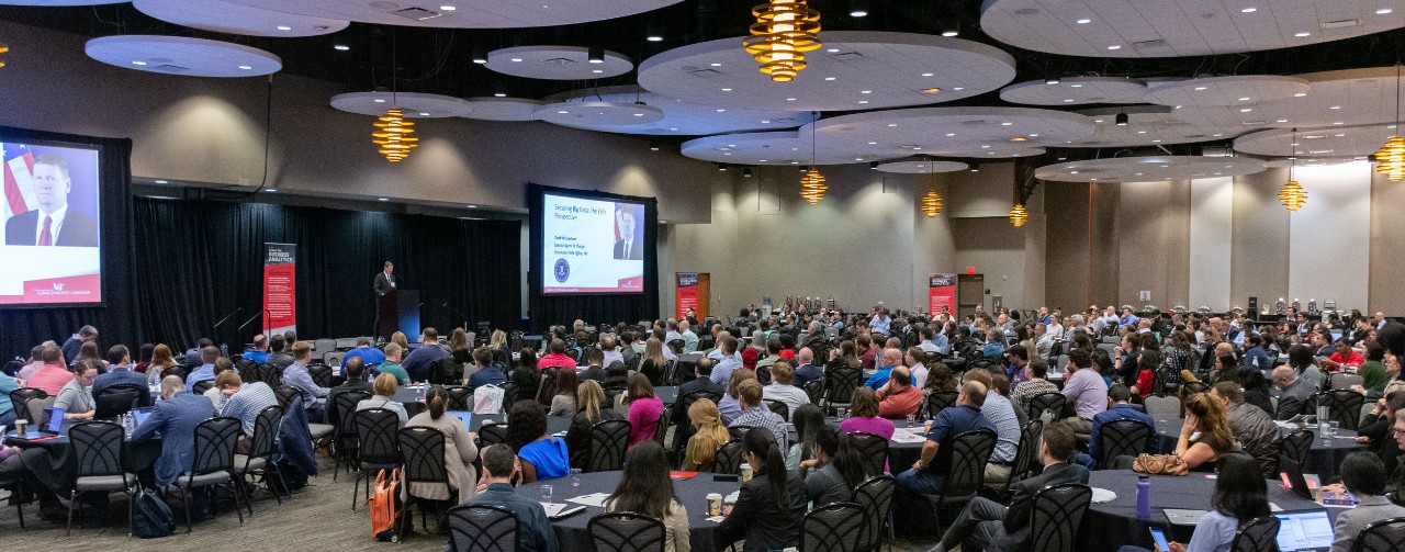 Several hundred 2019 Analytics Summit attendees sit in large conference room