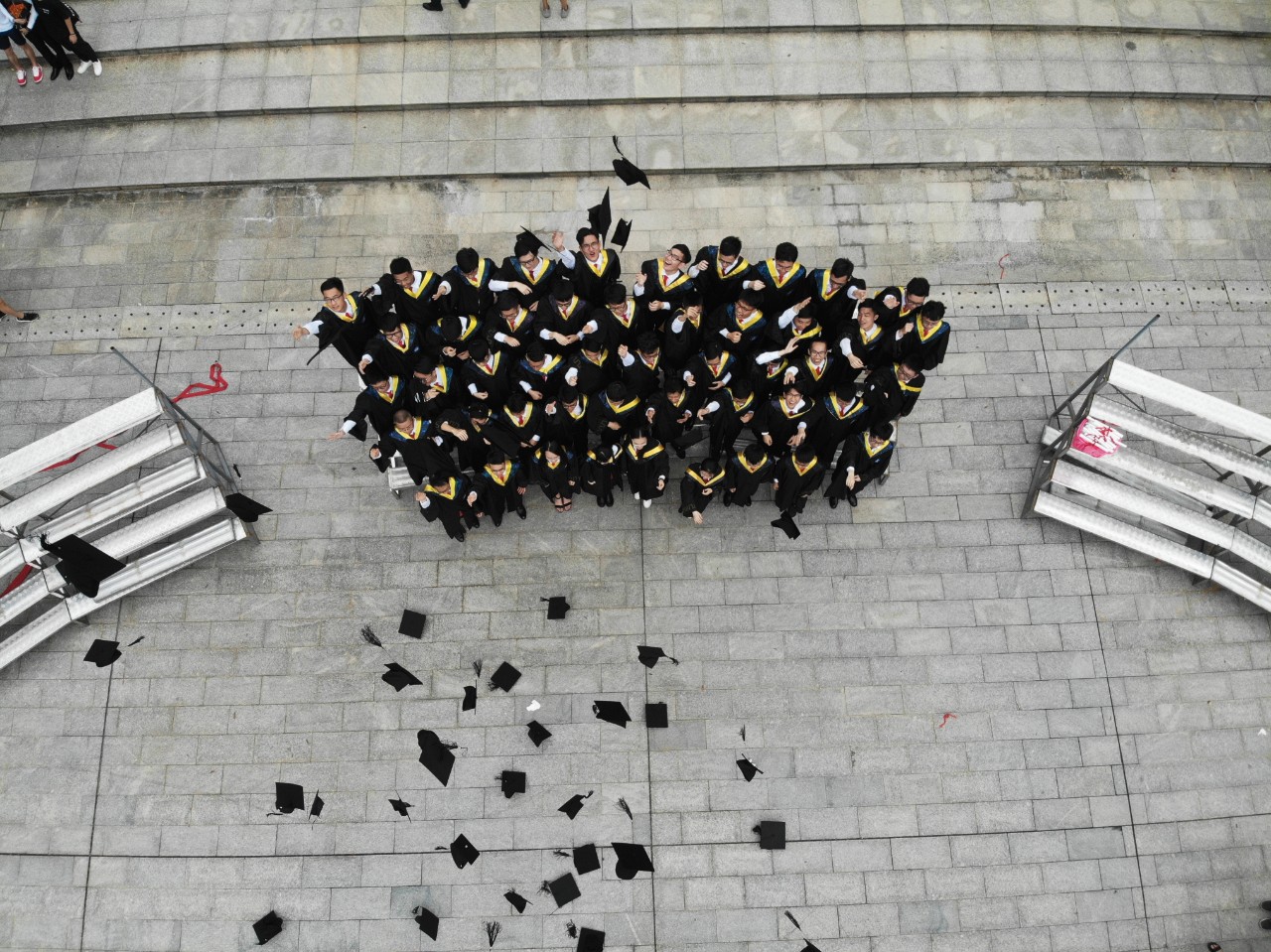 Aerial photo of a group of students tossing their caps in the air.