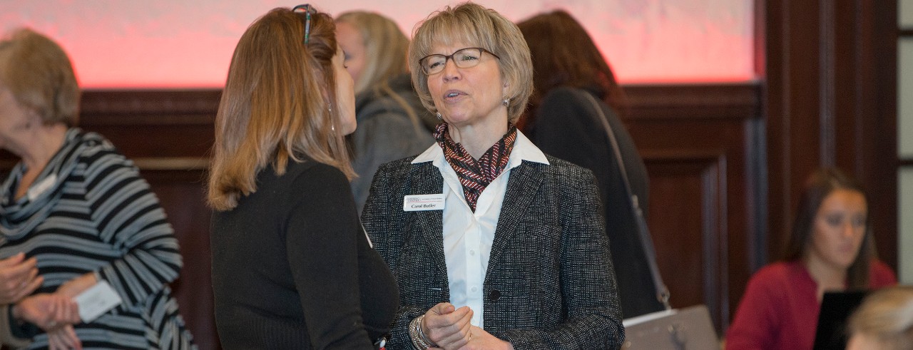 Goering Center president, Carol Butler, talking with peer Sonya Hall of Pathway Guidance at January luncheon.