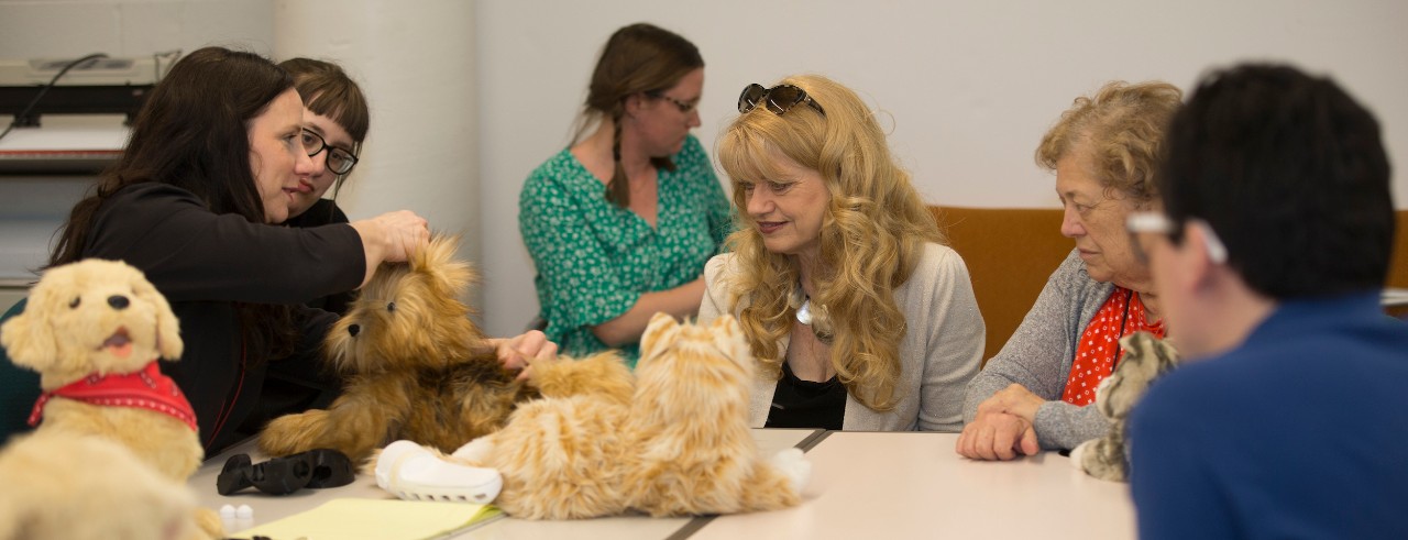 Students, teachers and seniors interact with a robotic cat and dog