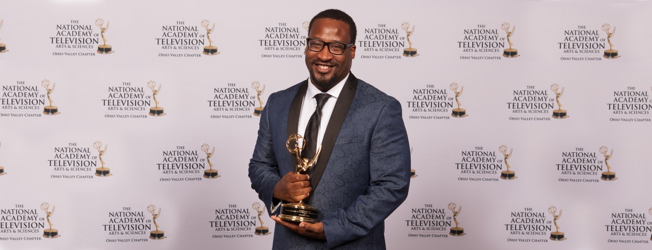 A picture of CCM faculty member Donald Hancock holding his Emmy Award.