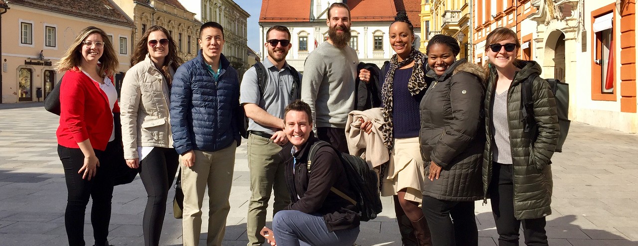 Group of UC advisors poses in a row in a town square in Varaždin, Croatia