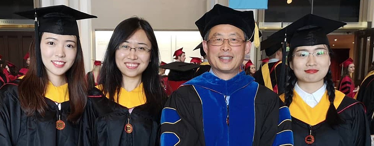Xiamen pharmacy students Yiyu Chen, Cheng Zhong and Chenyu Zou pose in their graduation robes with Professor Jeff Guo