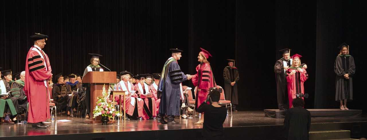 Dean Andrew Filak, MD, congratulations a graduating medical student.