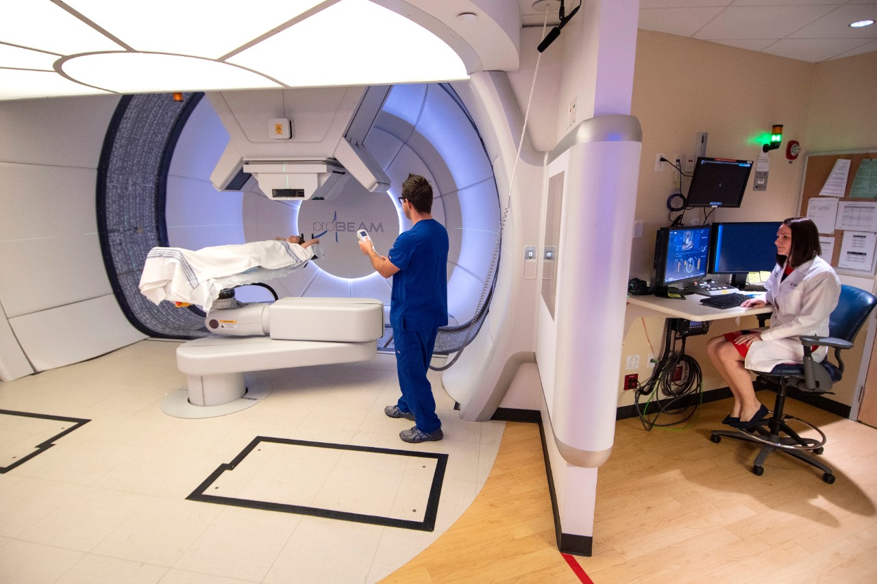 Teresa Meier in a proton therapy gantry with a patient and radiation therapist